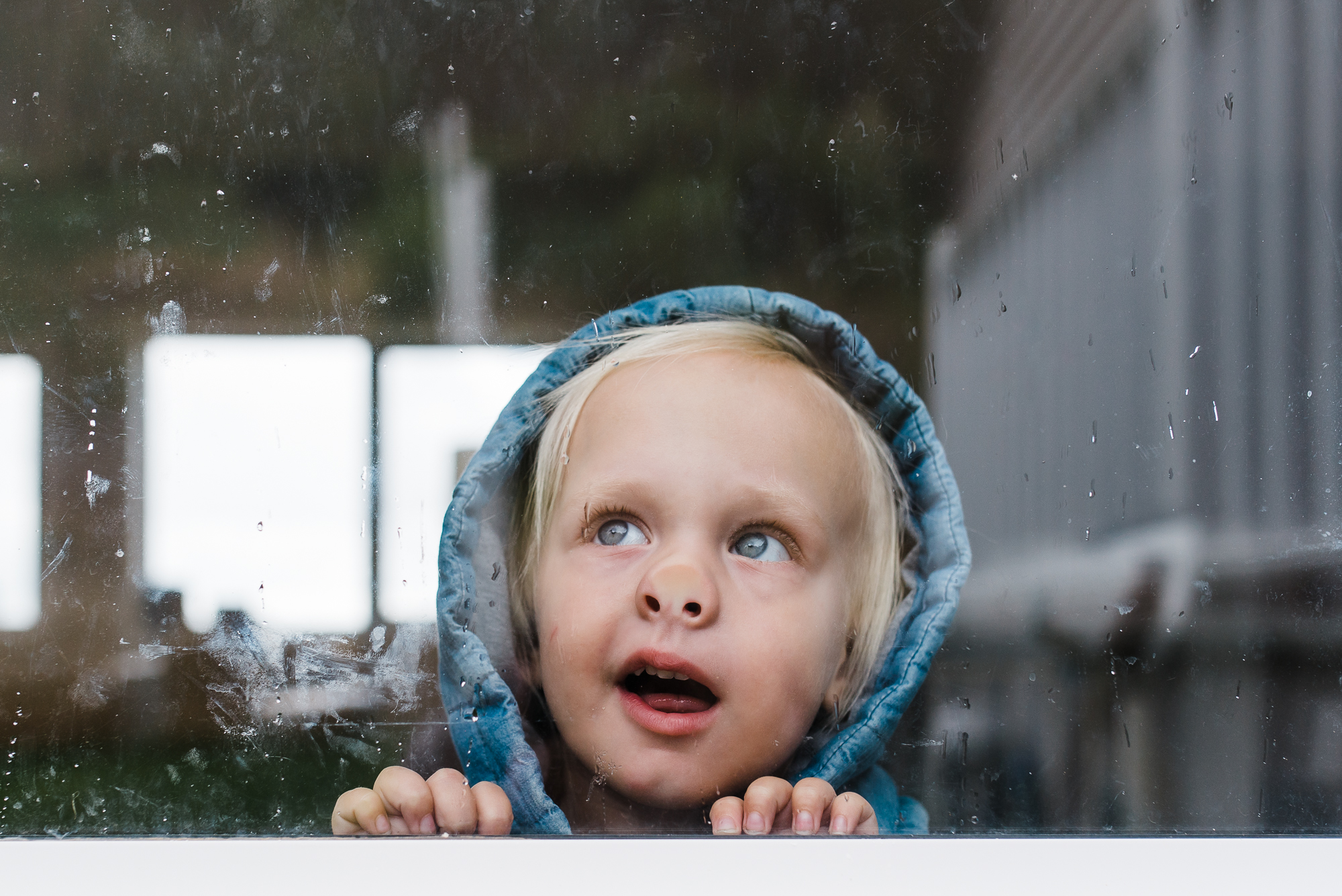 child with face pressed against window -Documentary Family Photography