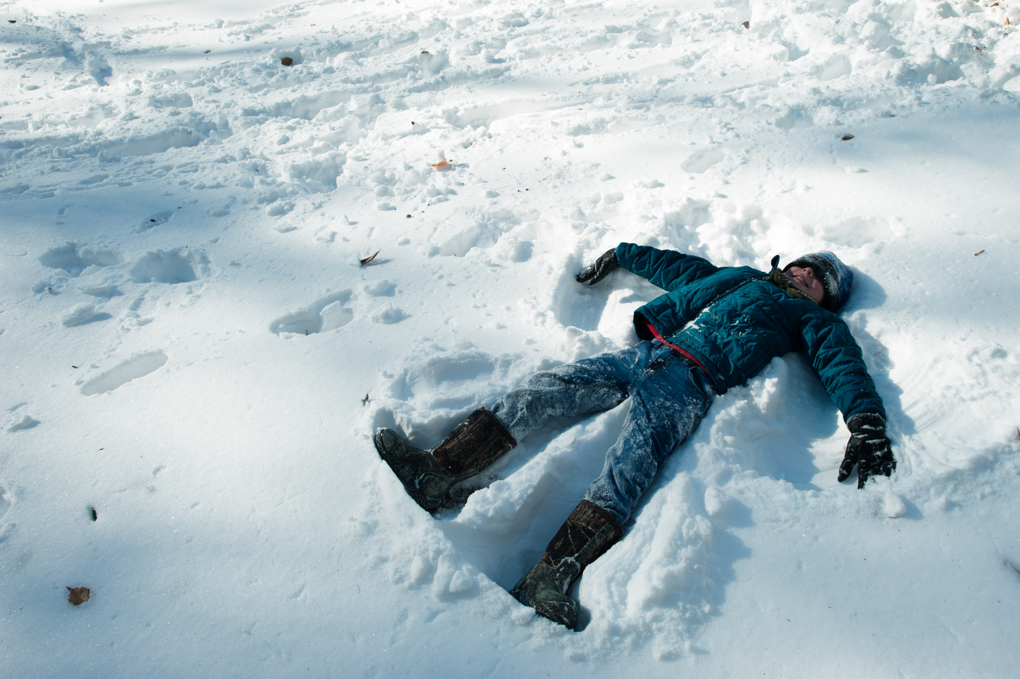 kid making snow angel - Documentary Family Photography